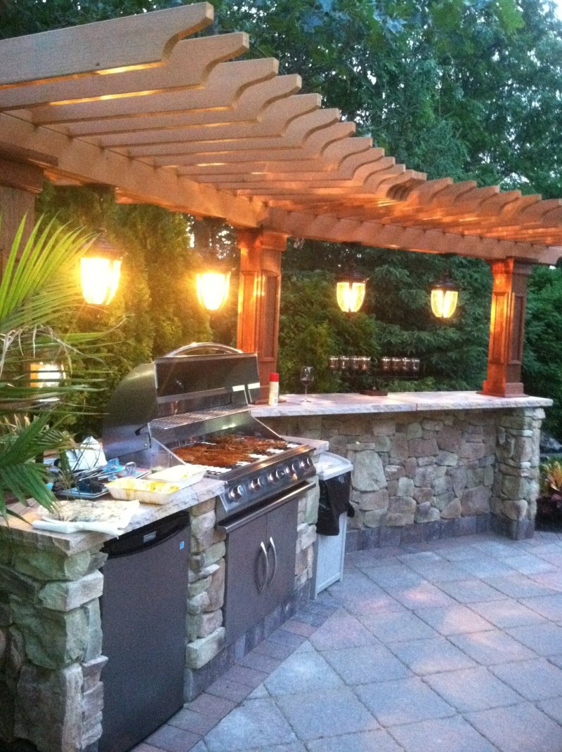outdoor kitchen island with pergola and lights